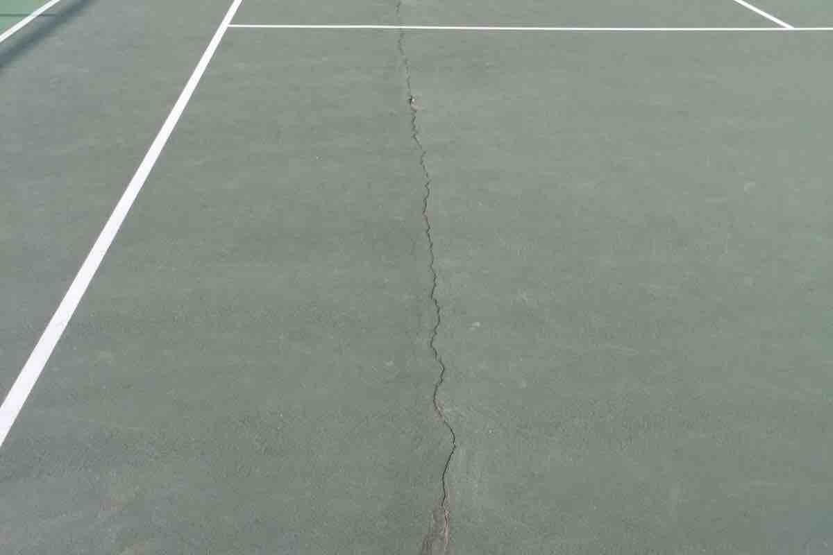 Camino Real Park tennis court with severe surface cracking running through the court