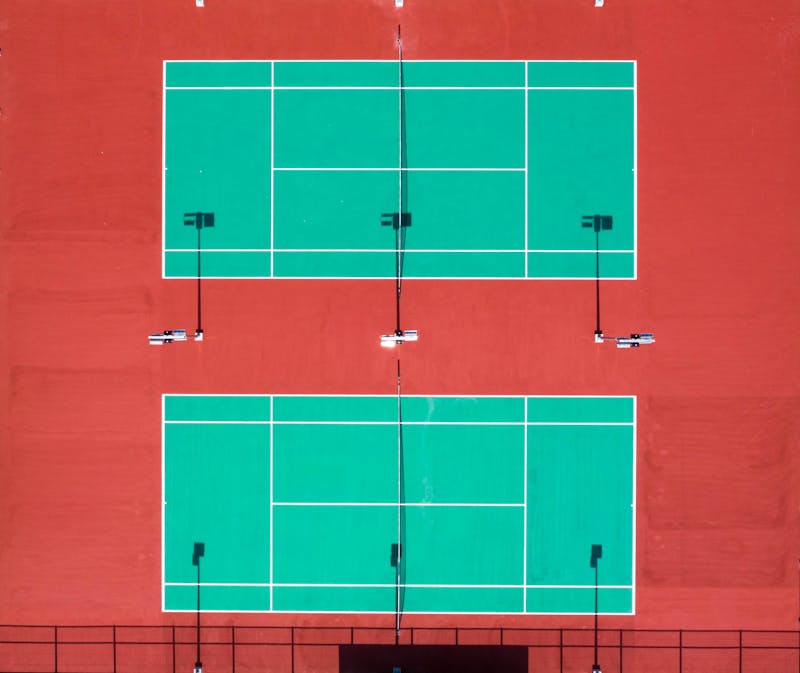 Well-maintained public tennis court with players actively using the facility